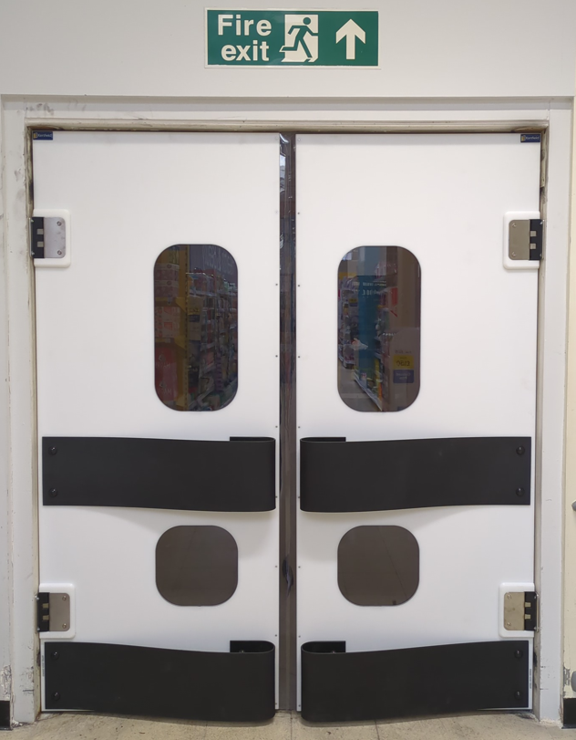 K150 white polyethylene double swing doors installed in a supermarket back-of-house corridor