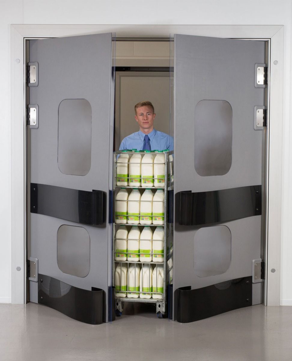 Staff member pushing a milk trolley through open grey K150 hygiene swing doors